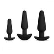 Load image into Gallery viewer, The 3 plugs from the b-Vibe Anal Training & Education Butt Plug Set in Black are shown against a blank background. The plugs are tapered with thin necks and flared, curved bases. They are arranged with the smallest on the left and largest on the right.