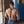 Load image into Gallery viewer, A shirtless, muscular man with brown hair stands beside a brick wall facing away from the camera. He is wearing blue jeans and the Deluxe Leather Suspenders. The suspender straps are Y-shaped and clip onto his belt loop.

