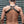 Load image into Gallery viewer, A brunette man wearing the black leather Contender chest Harness, a black thong, and an arm gauntlet poses in front of a metal wall. 
