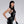 Load image into Gallery viewer, A woman with black hair and red lipstick poses in front of a grey backdrop. She wears the Latex Halter Top with a Zipper in black by Syren Latex. The top has a high neck and a silver zipper down the front. She also wears matching leggings and gloves.
